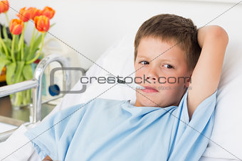 Boy in hospital bed with thermometer