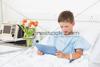 Boy using digital tablet in hospital