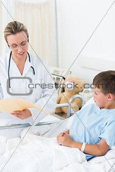 Doctor reading report of sick boy