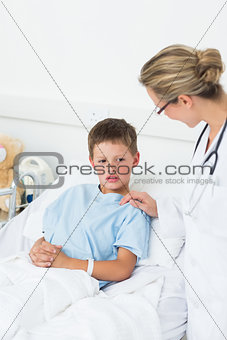 Doctor comforting little boy in hospital