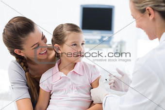 Girl receiving an injection by female doctor