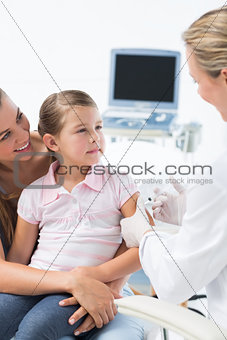 Girl receiving injection by pediatrician