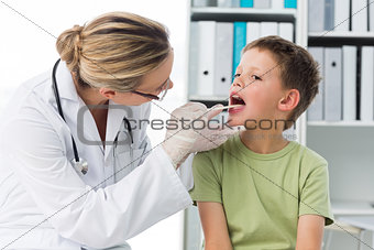 Doctor checking mouth of boy