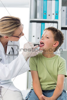 Doctor looking at the mouth of boy