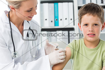 Boy receiving injection by female pediatrician