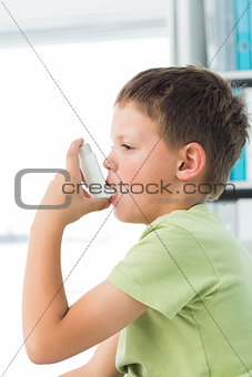 Boy using asthma inhaler in hospital