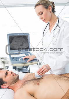 Cardiologist giving heart ultrasound to patient