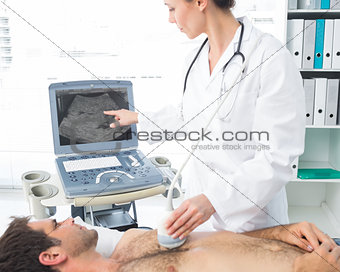 Cardiologist using sonogram on male patient