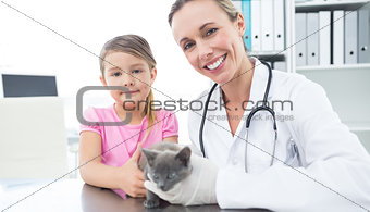 Vet and girl with kitten in clinic