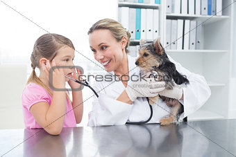 Vet with girl examining puppy