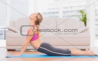 Fit blonde doing yoga on exercise mat