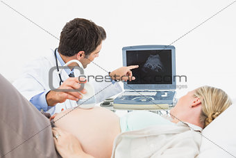 Doctor showing pregnant woman her baby on sonagram