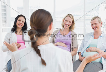 Pregnant women listening to doctor at antenatal class