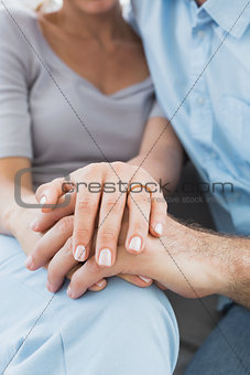 Couple showing wedding ring on womans finger on the couch