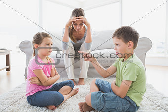 Fed up mother listening to her young children argue