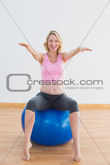 Pretty pregnant woman sitting on exercise ball
