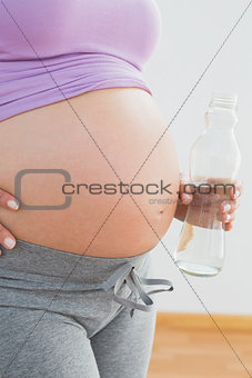 Pregnant woman holding bottle of water