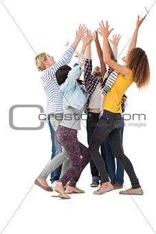 Casually dressed happy young people raising hands