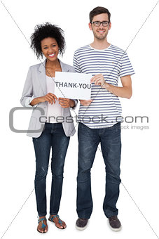 Portrait of a smiling couple holding a thank you note