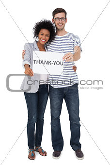 Portrait of a smiling couple holding a thank you note