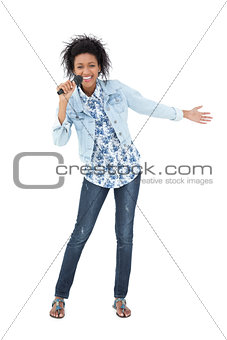 Full length of a young woman singing into a microphone