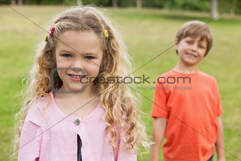 Two smiling kids standing at park