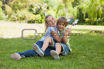 Two kids with pinwheels playing at park
