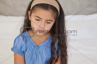 Close-up of a sad girl sitting on bed
