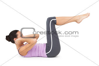 Side view of a fit young woman doing crunches