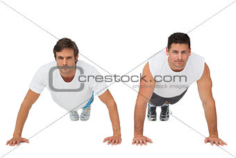 Portrait of two young men doing push ups
