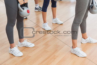Fit women exercising with kettlebells in the gym