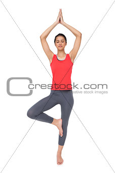 Full length of a fit woman standing in tree pose
