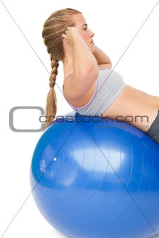 Fit young woman doing crunches on exercise ball