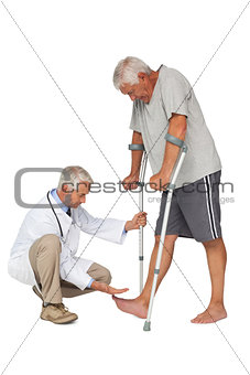 Side view of a doctor with senior man using walker