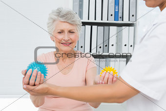 Doctor with senior patient using stress buster balls
