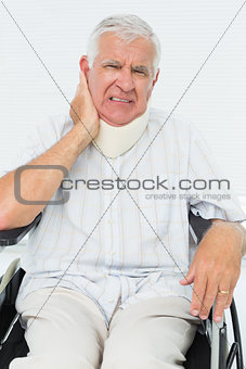 Senior man sitting in wheelchair with cervical collar