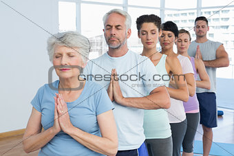 Sporty people with eyes closed and joined hands