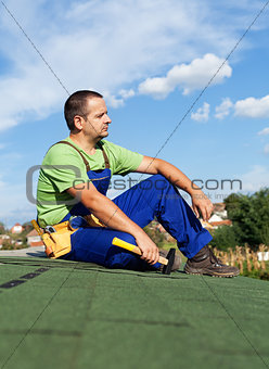 Roofer worker resting on top of building