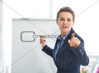 Business woman near flipchart pointing on listener