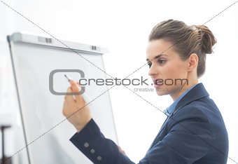 Business woman writing on flipchart