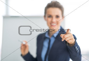 Closeup on business woman near flipchart pointing on listener
