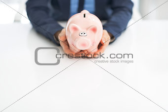 Closeup on business woman holding piggy bank