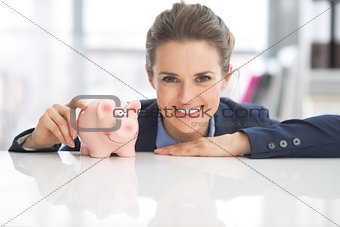 Portrait of happy business woman with piggy bank