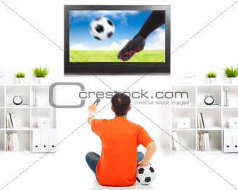 young fan watching soccer game at home