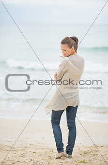 Young woman standing on cold beach