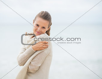 Portrait of happy young woman on cold beach