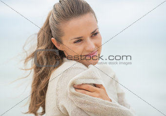 Portrait of happy young woman on cold beach