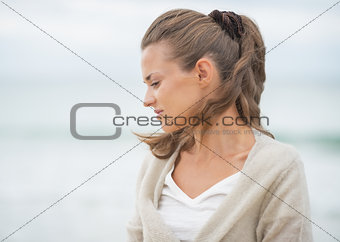 Portrait of relaxed young woman on cold beach