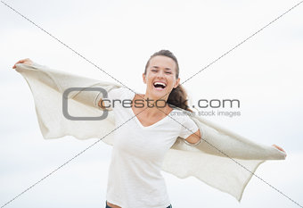 Happy young woman on cold beach rejoicing
