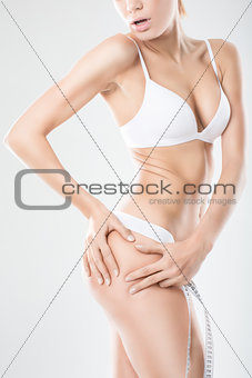 Female squeezing cellulite skin on her buttocks